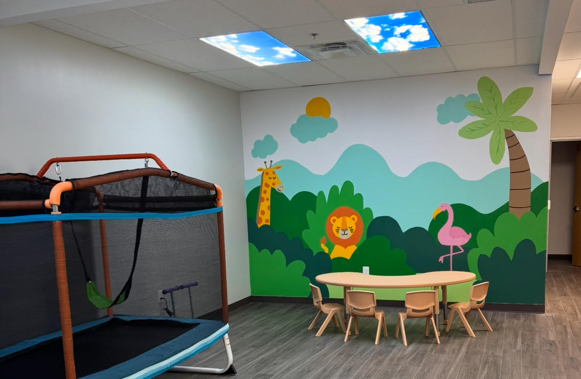 Colorful play area with a mural at our Frisco center